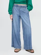 Pantalón de jean celeste, corte ancho, con cintura elástica y bolsillos laterales.