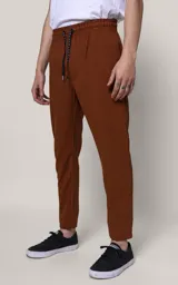 Pantalón de jogging color marrón chocolate, de corte recto y calce regular, con cintura elástica ajustable con cordón, bolsillos laterales y puños con cierre.