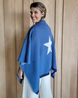 Ruana de algodón, color azul con estrella blanca en la parte posterior, diseño versátil y elegante.