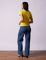 Buzo amarillo tejido en hilado fino, con cuello redondo y mangas cortas.