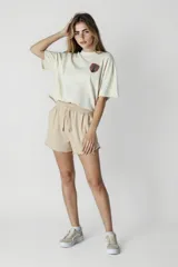 Remera color crudo de corte cropped con estampado pequeño en el pecho.