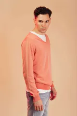 Sweater de punto color salmón con cuello en V.