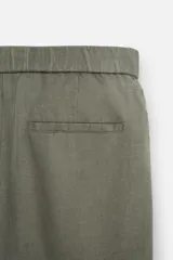 Pantalón negro regular fit confeccionado en tejido de lino. Cintura ajustable con cordón interior, bolsillos frontales y detalle de bolsillos traseros de vivo.