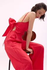 Pantalón de lino rojo de corte palazzo con lazo en la cintura.