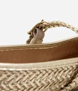 Zapatilla chatita metalizada dorada con puntera redonda, tira con hebilla y textura trenzada.