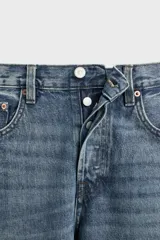 Pantalón de jean gris de corte recto, con cinco bolsillos, efecto lavado y cierre frontal con botones.