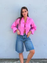 Camisa rosa de lino con cuello, manga larga con puños acampanados y cierre frontal anudado.