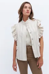 Chaleco celeste de lino con cuello mao, cierre frontal con botones y volados en hombros y bolsillos.