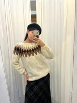 Sweater tejido a mano en Uruguay con lana merino color crudo, con diseño geométrico en tonos marrón y beige en la parte superior.