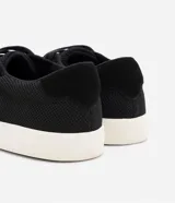 Championes negros de poliéster con textura, caja baja, puntera redonda y cierre con cordones.