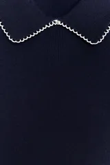 Top azul marino de punto con cuello solapa y manga corta. Detalle de acabados con vivos blancos a contraste en cuello y mangas.
