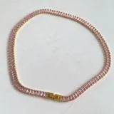 Collar choker elegante de acero hipoalergénico enchapado en oro, con incrustaciones de circonia y diseño en color negro.
