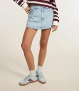 Short pollera de jean celeste con tiro alto, bolsillos delanteros y traseros, y trabillas en la cintura.