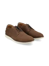Zapato de vestir de hombre color marrón, estilo casual-formal, con cordones y suela blanca de goma. Presenta un detalle de cuero oscuro en el talón.