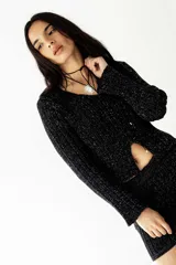 Buzo negro de lurex con tajo delantero y mangas largas.