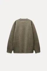 Sweater estilo sudadera color verde oliva, confeccionado con lana. Tiene cuello redondo y mangas largas.