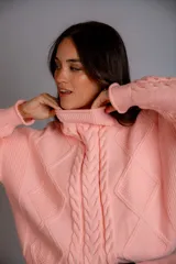 Sweater color crudo con cuello alto y diseño trenzado.