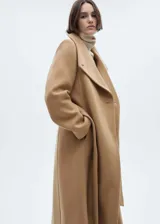 Abrigo largo color camel con cuello chimenea, cierre cruzado con botones y lazo ajustable en la cintura.