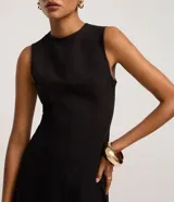 Vestido sin mangas, largo midi, color celeste claro, con escote redondo y corte evasé. Presenta breteles anchos y cierre trasero con cremallera.