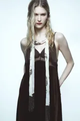 Vestido midi de terciopelo negro con escote pico y tirantes finos ajustables. Detalle de encaje en contraste en el escote.