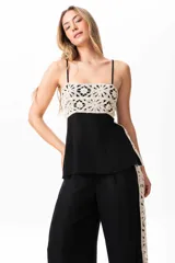 Musculosa negra con breteles finos regulables y detalle de broderie calado color crudo en el frente.