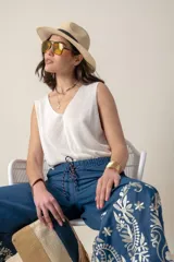 Pantalón italiano de jean azul con bordados florales en color crema. Tiene cintura elastizada con cordón ajustable y bolsillos laterales.