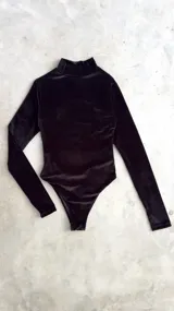 Body de terciopelo marrón con estampado de piel de serpiente, cuello alto, mangas largas con orificio para el pulgar y espalda descubierta.