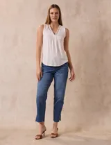Blusa sin mangas color blanco, marca Absolutely Famous, confeccionada en seda fría. Presenta escote en V con detalle de lazo entrelazado.