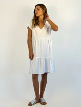 Vestido corto de algodón color naranja, con corte evasé y volados en el ruedo.