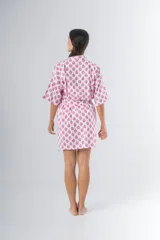 Bata kimono corta de algodón estampado con flores rojas, violetas y verdes. Tiene mangas al codo y lazo de ajuste en la cintura.