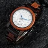 Reloj Chenaut Perle d’Ébène con caja de madera de sándalo rojo, esfera blanca perlada con manecillas azules y malla de madera de ébano.