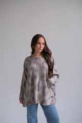 Sweater oversized de cuello redondo, manga larga caída y estampado animal abstracto en tonos verde y gris.