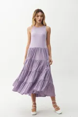 Vestido midi color lila, con cuerpo superior ajustado de punto canalé y falda amplia de tres niveles con textura arrugada.