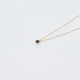 Conjunto de collar doble con cadena de oro amarillo 18k. El collar superior tiene un dije de zafiro engarzado en 4 puntas, y el collar inferior tiene un dije de flor negra con centro de zafiro.