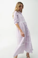 Vestido camisero midi color beige a rayas verticales, con cuello mao, mangas 3/4 abullonadas y festones de algodón en el cuerpo. Cierre frontal con botones.