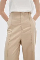Pantalón de lino color beige, de corte recto y tiro alto, con bolsillos laterales.