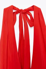 Vestido midi negro de tejido fluido, con cuello halter que se ata al cuello, escote en V y espalda descubierta.