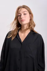 Camisa negra de liocel con cuello clásico, cierre frontal con botones, manga larga y bolsillo de parche en el pecho.