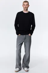 Remera negra de punto de algodón liviano, de corte estándar, cuello redondo ribeteado y mangas largas.