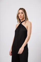 Mono largo negro de punto con escote halter y corte palazzo. Incluye un collar largo con dijes de estrellas plateadas.
