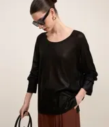 Blusa negra de punto liviano con escote redondo, manga larga y sisa raglán. Tiene una malla con lámina metálica.
