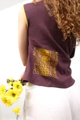 Remera color borgoña de corte crop, con mangas cortas con ribete amarillo y hombros descubiertos.