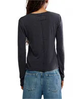 Remera de manga larga color gris oscuro, con cuello redondo y terminaciones al corte. Está confeccionada en una mezcla de algodón orgánico y reciclado, ofreciendo un calce entallado y cómodo.