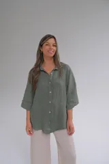 Camisa verde militar de lino italiano, de corte holgado, con cuello clásico, cierre frontal con botones y mangas 3/4 con botón para ajustar el largo.