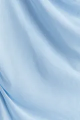 Vestido corto celeste de malla, con breteles finos, escote drapeado y frunces laterales.