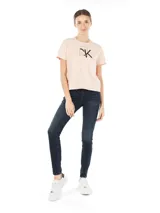 Remera cropped color rosa claro de algodón y elastano, con logo "CK" enmarcado en negro en el frente.