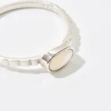Anillo plateado con piedra ovalada de nácar.
