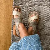 Sandalias negras de cuero con hebilla plateada y taco de madera.