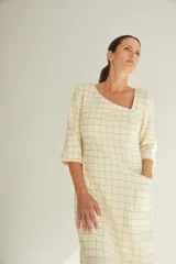 Vestido midi color crema con escote cuadrado, manga francesa con tajo y bolsillo lateral. Confeccionado en lana fina sin teñir.