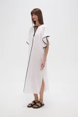 Túnica blanca de algodón con cuello en V, manga corta y ribete negro.